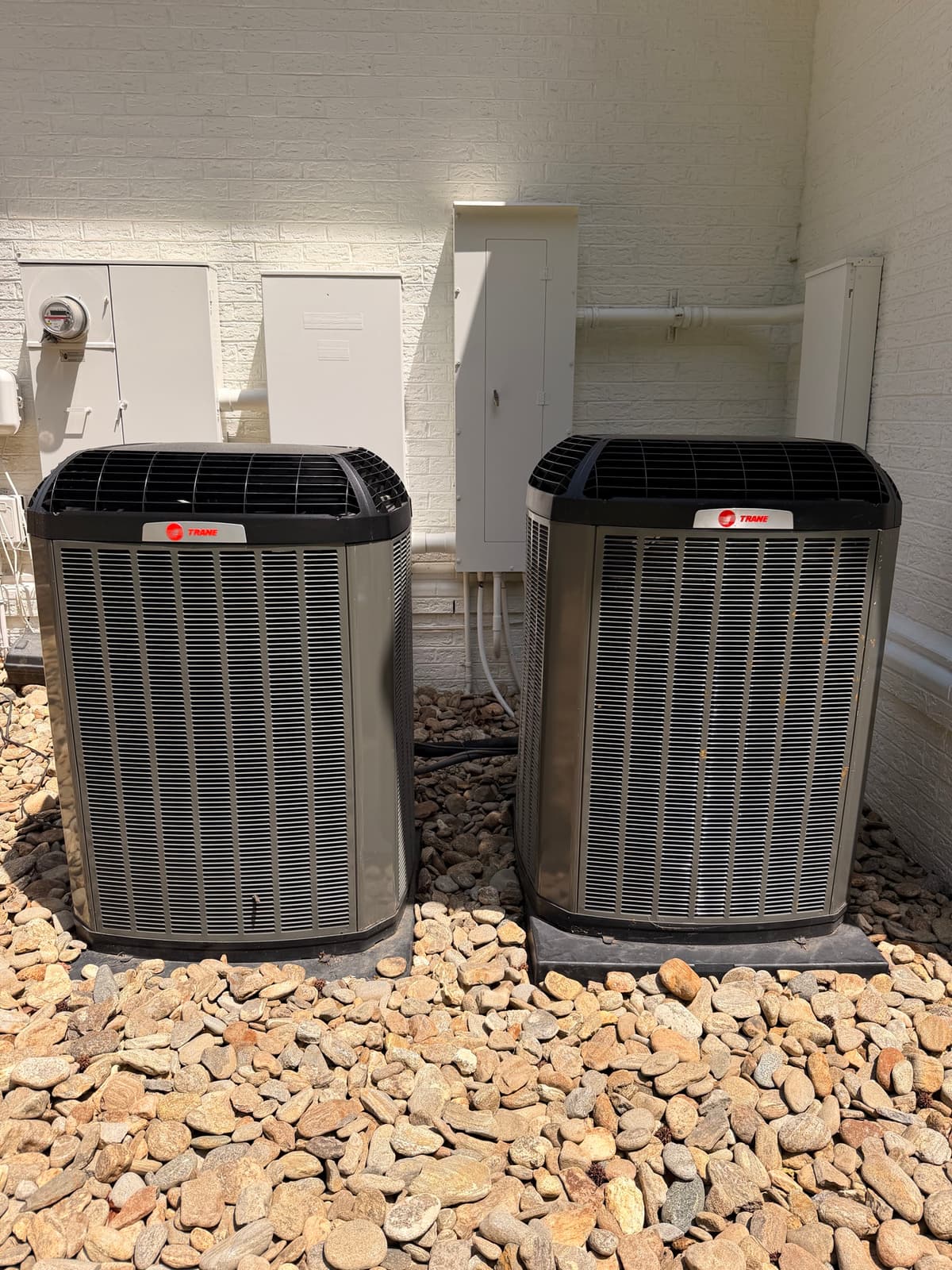 Two Trane outdoor condensers installed on gravel pads